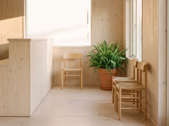 Reception with timber panelling and a plant