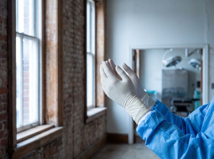 The surgeon’s gloved hands at the theatre window