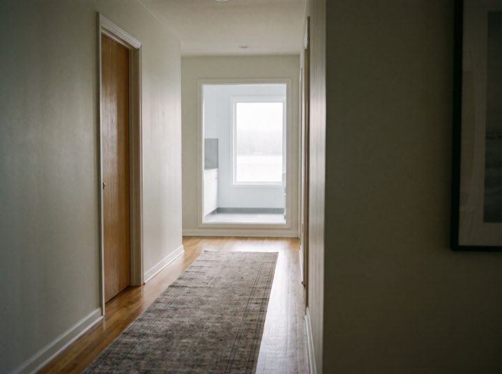 The corridor, empty, with a window at the far end