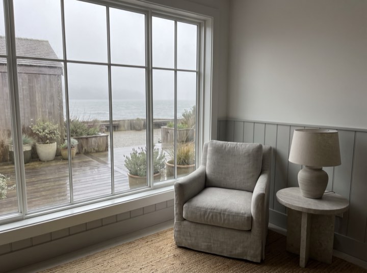 The lounge, one armchair by a window onto water