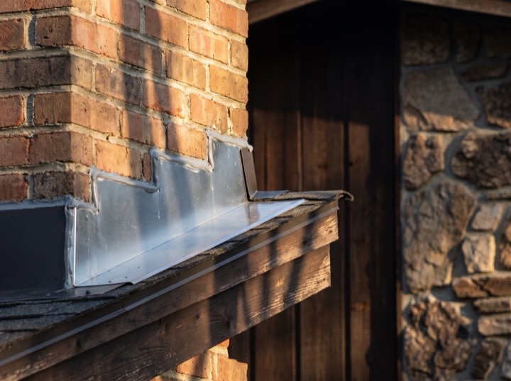 New step flashing against a brick chimney