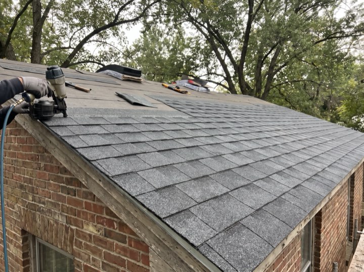 New shingle courses being nailed on a brick house