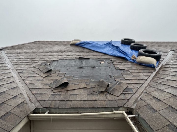 Hail-damaged roof before work began