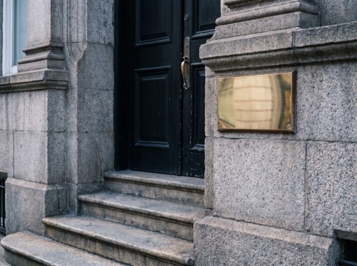 The firm's black front door with a brass plate, up three stone steps