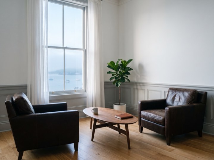 Two leather armchairs and a low table by a tall window